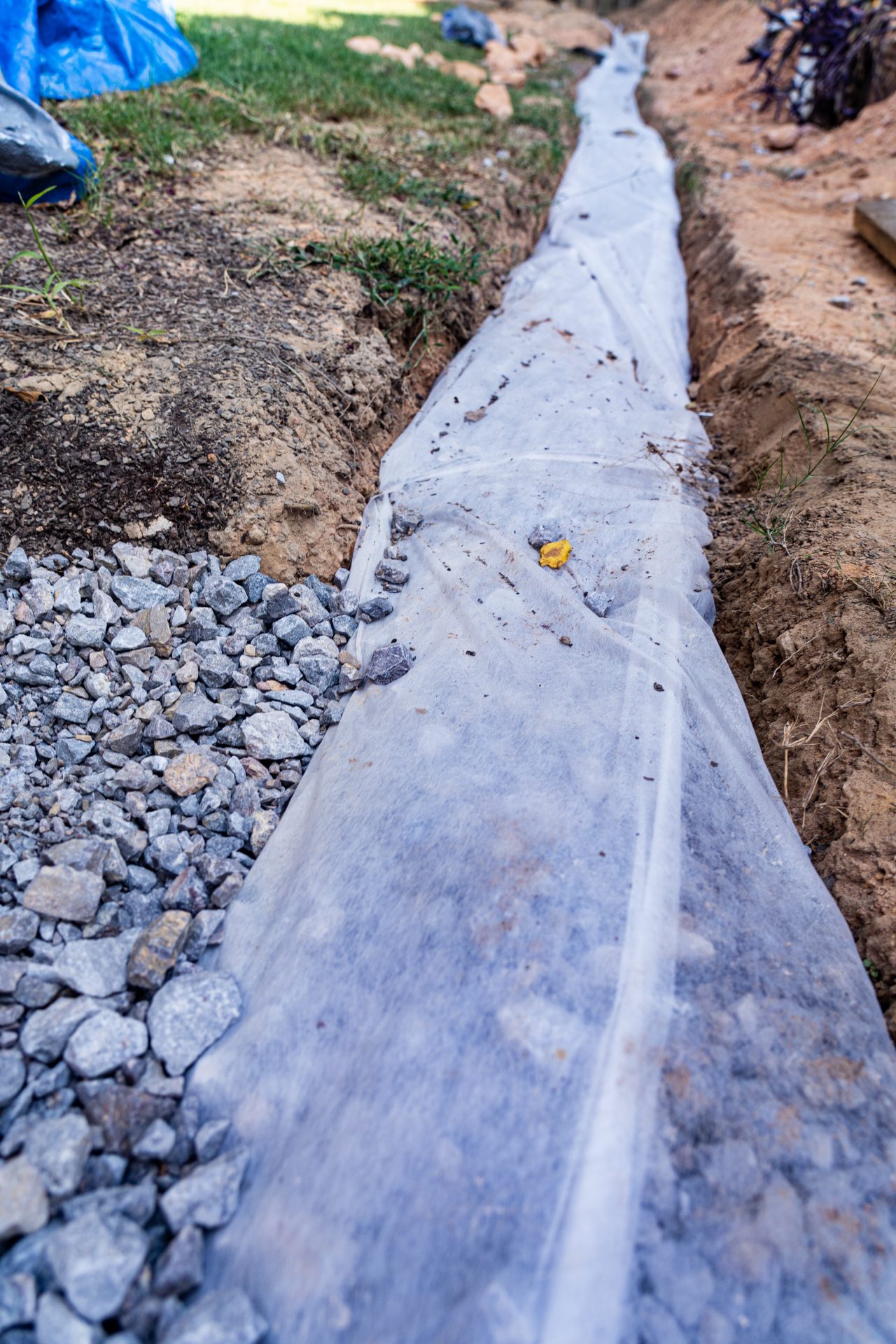 Check The Slope Of The Drain The drain should be placed on the ground that slopes downwards to allow the flow of water by gravity and prevent blockage. Check the direction in which rainwater flows when it rains to figure out the slope. You can adjust the pitch of your preferred path if your home is on flat ground as you dig out the trench for the system. Ensure the drain slopes away from your home or any nearby buildings, including your neighbor’s houses, to avoid future lawsuits.